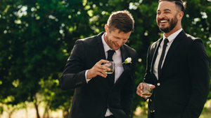 groom and groomsmen smiling and drinking cheerfully outside